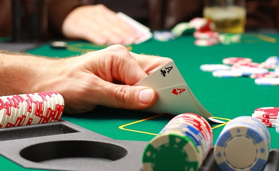 Man playing pokerMan checking his cards during poker game ID 4